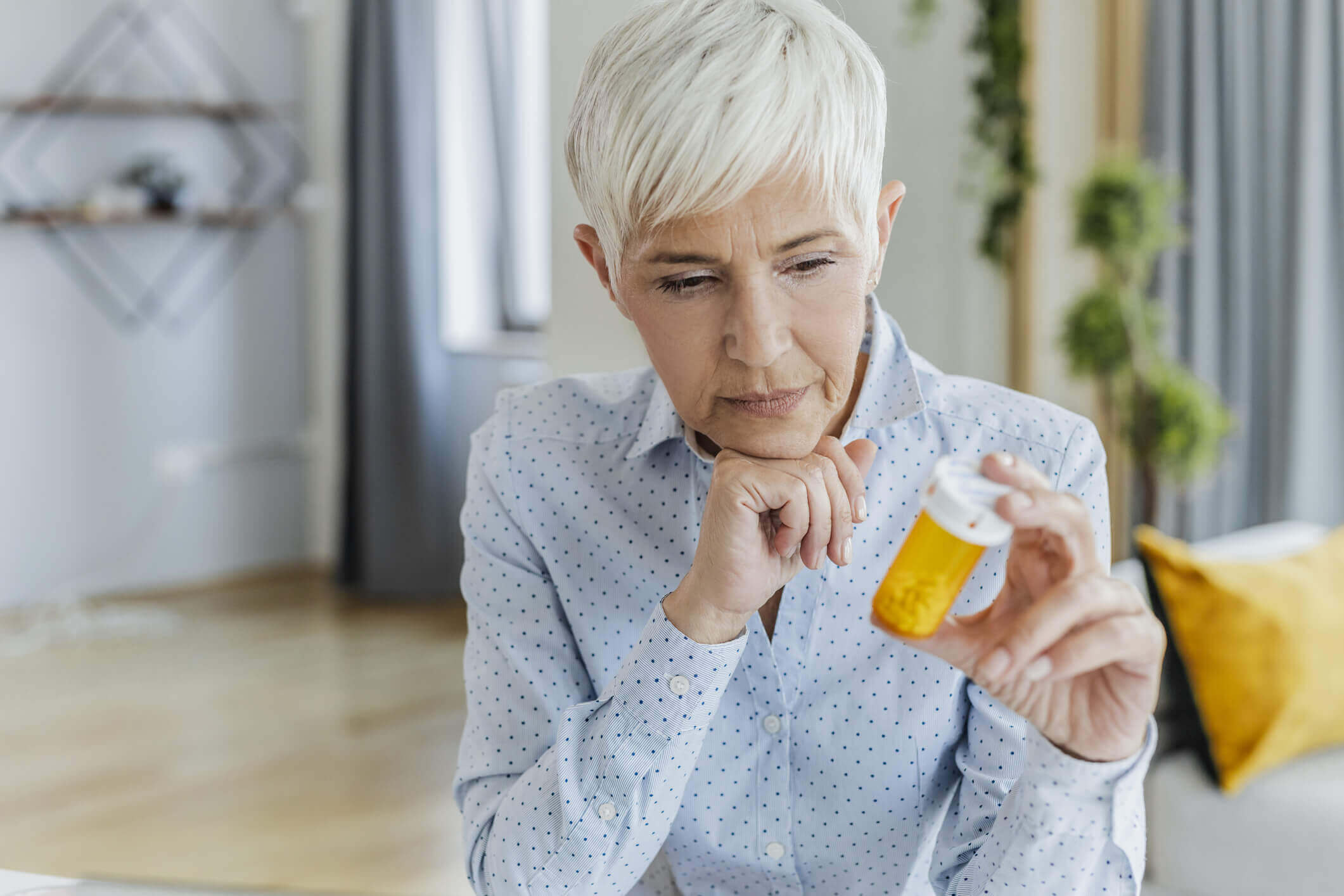 A old woman holding medicine bottle